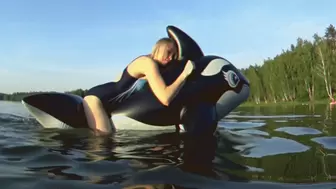 I'm riding a big black inflatable whale on the lake!!!