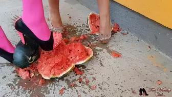 Two girls in high heels crushing watermelon
