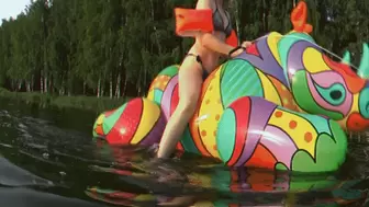 Alla rides an inflatable rhinoceros on the lake and blows it away at the same time and wears inflatable Bema bandages on her hands!!!