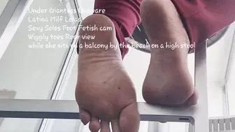 Under Giantess Unaware Latina Milf Lolas Sexy wrinkled Soles Foot Fetish cam Wiggly toes Rear view while she sits on a balcony by the beach on a high stool