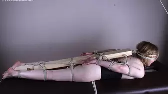 Wearing only a black corset barefoot blindfolded with rope Florence, lying on a couch, bound to a wooden stick at her feet, ankles, knees, thighs, hands, elbows and head, is teased by a camera man (HD WMV)