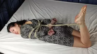 Norma: hogtied with hemp rope barefoot girl, wearing a dress, with nails painted in red, is wiggling on the bed, then tickled by camera man (HD WMV)