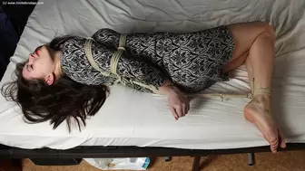 Norma: hogtied with hemp rope barefoot girl, wearing a dress, with nails painted in red, is wiggling on the bed, then tickled by camera man (HD MP4)