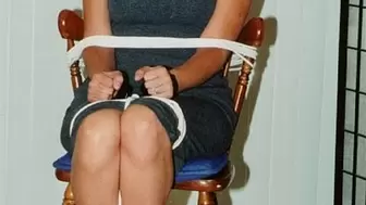 Her wrists handcuffed in front, dark-haired struggler Becky Rico sits roped to a chair and tape-gagged!