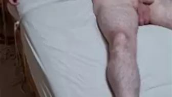Naked man spreadeagled on bed