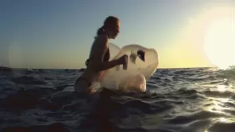 Alla swims astride a transparent rare inflatable whale on the sea!!!
