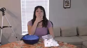 Stuffing marshmallows in her mouth