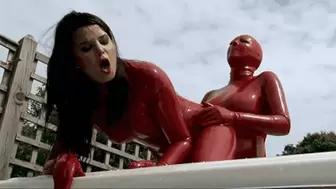 Red latex catsuit lesbians with strap-on in bathtub outdoor