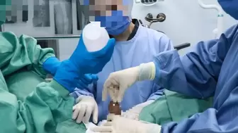 Three Japanese in surgical gowns are examined and given hand jobs