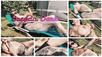 Tattooed horny brunette with big boobs sunbathing in the yard and rubbing sunscreen on her tits