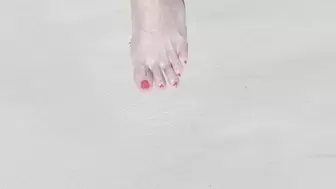 Tempest walking on the beach and showing off her red toes