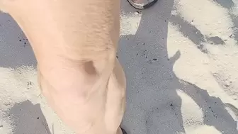 Walking in sand in black thong flip flops