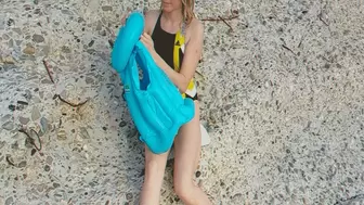 Alla deflates a blue inflatable vest on the beach and folds it compactly!!!