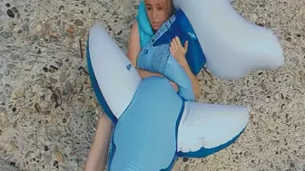 Alla blows off a blue transparent inflatable whale on the beach and wears an inflatable vest!!!
